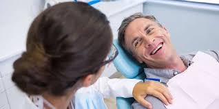 Profissional odontológico conversando com paciente